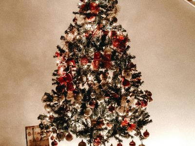 Traditional home Christmas tree in UAE decorated with red baubles, warm fairy lights, and a dark star topper.