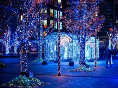 A contemporary outdoor Christmas display designed as a mini light festival featuring a blue and white LED spiral tree in Dubai.